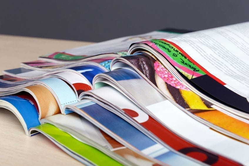 Magazines on wooden table on gray background Magazines on wooden table on gray background